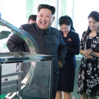 Kim Jong-un durante la visita a la fábrica, junto a su mujer, Ri Sol-ju (segunda por la derecha), en una foto difundida el domingo por la KCNA.-AFP / KCNA