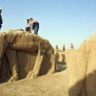 Trabajadores iraquís limpian las estatuas en el sitio arqueológico de Nimrod, en el 2001.-Foto: AFP / KARIM SAHIB