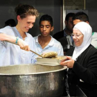 Asma el Asad, en un reparto de comida a huérfanos y desplazados en Damasco, en el 2013.-ARCHIVO / AFP
