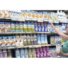 Una clienta elige leche entre la gran variedad de oferta del supermercado.-RICARD CUGAT