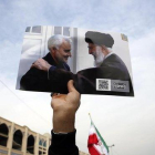 Un manifestante muestra la foto del guía supremo, Alí Jamenei, junto al general Qasim Soleimani.-EFE / ABEDIN THAERKENAREH