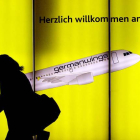 Una mujer pasea por delante de un cartel publicitario de Germanwings en el aeropuerto de Colonia, en Alemania.-Foto:   OLIVER STRATMANN / AFP