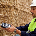 Un operario de la planta de biomasa de Briviesca realiza controles sobre varios fardos de paja de cereal.-ACCIONA