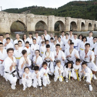 Los karatekas del ShinGiTai posan con sus karateguis frente al puente de Cabezón.-J.M. LOSTAU
