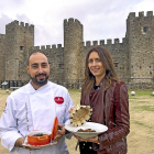 Santiago y Ana, con algunos de los platos de su restaurante en Montemayor del Río, delante de la fachada del Castillo./ E.M.