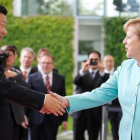 La cancillera alemana Angela Merkel da la bienvenida al presidente chino Xi Jinping.-AXEL SCHMIDT