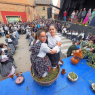 Dos chicas realizan el tradicional pisado de la uva en las fiestas de Rueda. Al fondo, un grupo de mujeres ofrece un espectáculo de baile tradicional.-MIGUEL ÁNGEL SANTOS