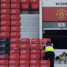 Miembros de seguridad rastrean las gradas de Old Trafford.-AFP / OLI SCARFF