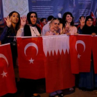Mujeres con banderas turcas y qatarís en Estambul.-REUTERS / MURAD SEZER