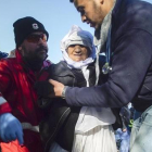 Voluntarios ayudan a una mujer anciana de Afganistán tras desembarcar con otros refugiados en Skala Sykaminias, en Lesbos, este miércoles.-AP / MSTYSLAV CHERNOV