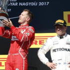 Sebastian Vettel celebra su victoria en Hungría ante Valttri Bottas.-AP / DARKO BANDIC