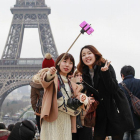 Turistas utilizando del palo para hacerse selfis en París.-