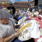 Varias mujeres entretejen sus encajes de bolillos, ayer en la Plaza Mayor durante el II encuentro celebrado con motivo de las fiestas patronales.-J.M. LOSTAU