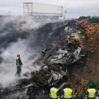 Los Bomberos apagan el fue del camión que quedó destrozado por el fuego y el impacto.-B. González