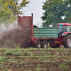 Un agricultor realiza trabajos agrícolas con maquinaria sobre un campo recién abonado.-ECB