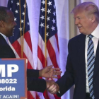 Trump (derecha) estrecha la mano del excandidato Ben Carson, en Palm Beach (Florida), este viernes.-REUTERS / CARLO ALLEGRI