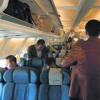 Varios pasajeros se acomodan en un avión del puente aéreo.-ARCHIVO / JON BARANDICA