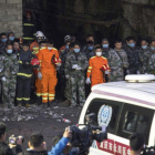 Los equipos de rescate hacen un minuto de silencio por los mineros muertos tras encontrar sus cuerpos sin vida, el martes, en la provincia de Chongqing (China)-AP / LIU CHAN