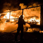 Los bomberos intentan apagar el fuego.-BOMBEROS DE LEÓN