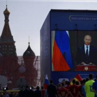 Un grupo de funcionarios y jugadores de fútbol miran el discurso televisado del presidente ruso, Vladimir Putin, en la Plaza Roja de Moscú, este viernes.-AP