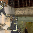 Los bomberos recogen las losas que se desprendieron de la pared del paso subterráneo.-Miguel Ángel Santos