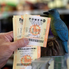Un hombre muestra sus billetes de lotería Powerball en la tienda de licor Bluebird el 22 de agosto de 2017, en Hawthorne, California (EE.UU.).-EFE