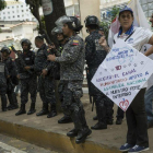 Policías venezolanos vigilan durante las protestas en contra de Nicolás Maduro.-AP
