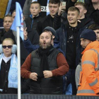 Un aficionado del Manchester City hace gestos racistas a los jugadores del United.-EFE / PETER POWELL