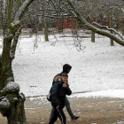 Dos chicos atraviesan un parque del barrio de Parquesol cubierto con una fina capa de nieve, ayer, a primera hora de la mañana-J. M. LOSTAU