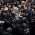 Agentes de la Policía Nacional intentan desalojar a las personas concentradas en las puertas del colegio Ramón Llull de Barcelona el 1-O.-FERRAN NADEU