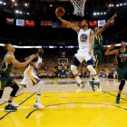 El jugador de los Warriors de Golden State Stephen Curry (c) entra a canasta a pesar de la defensa de Boris Diaw (2º dcha) y Rudy Gobert (dcha).-EFE