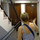 Una de las vecinas señala la puerta del piso donde vivía la niña asesinada junto con su familia.-J.M. LOSTAU