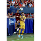 El delantero argentino de Osasuna Chimy Ávila (i) disputa un balón con Carles Pérez, del FC Barcelona, en el partido correspondiente a la 3ª Jornada de LaLiga Santander que Osasuna y FC Barcelona disputan hoy sábado en el estadio El Sadar, en Pamplona.-EFE