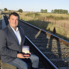 Paco Cañamero posa con su libro Aquella mañana de diciebre en las vías de tren donde tuvo lugar el accidente ferroviario.-ARGICOMUNICACIÓN