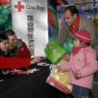 Una niña entrega un juguete en una recogida organizada por Cruz Roja en el paseo principal del Campo Grande (Valladolid)-J.M.Lostau