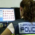 Una agente de la Policía Nacional examina imágenes con contenido pedófilo en un registro domiciliario.-POLICÍA MUNICIPAL