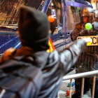 Un manifestante lanza una pelota a un policía, este sábado junto a la jefatura de Via Laietana-