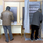 Dos hombres eligen papeletas en un colegio electoral de Valladolid.-ICAL