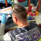 Un agente de la Policía Nacional toma fotografías en el ordenador del detenido, A. J.C.M., de 50 años, residente en un piso céntrico de Valladolid.-E. M.