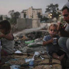 Una familia en el cementerio de Almaamadani, en Gaza.-Foto: ALI ALI / EFE