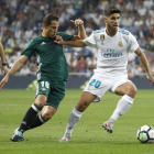 Asensio conduce el balón perseguido por Guardado durante el último Real Madrid-Betis.-JUANJO MARTÍN / EFE