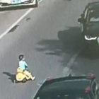 Un niño chino se mete con su coche de juguete en una autopista en hora punta.-