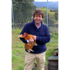 César Redondo posa con una de las gallinas que vive en los chalés de la Granja Redondo.-E. M.