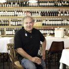 Roberto Aldea posa con una copita de vino ante una de las dos paredes del comedor repleta de referencias vinícolas vinculadas a la tierra que dentro del Kiosco.-LUIS ÁNGEL TEJEDOR