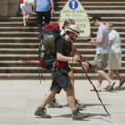 Dos peregrinos pasan a pie frente a la escalinata de la Puerta del Sarmental de la Catedral de Burgos.-SANTI OTERO