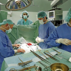 Los cirujanos se concentran para extraer el corazón enfermo.-Ical