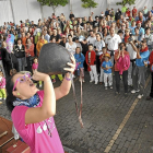 Una joven se divierte en el concurso de beber en bota de la localidad vallisoletana de Olmedo.-EL MUNDO