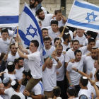 Manifestantes israelís celebran la aprobación de la ley en el Parlamento. /-AP / ARIEL SCHALIT