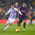 Guardiola corre tras el balón ante el marcaje de Vidal.-PHOTO-DEPORTE