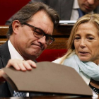 Artur Mas mira bajo una carpeta en el Parlament, junto a la vicepresidenta Joana Ortega.-Foto: EFE / ALBERTO ESTÉVEZ